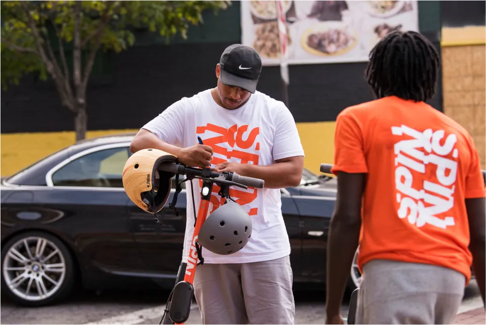 Two Spin team members setting up a scooter